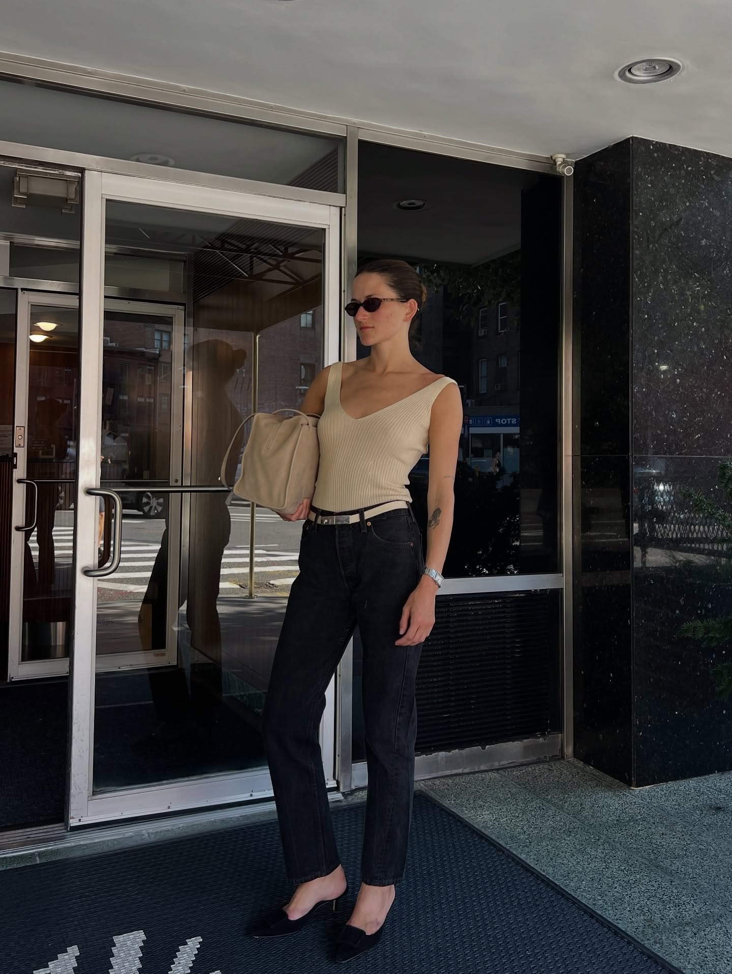 @elizagracehuber wearing a tan Prada tank top with black Levi's straight-leg jeans.