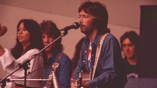 Eric Clapton performs on stage with singer Yvonne Elliman and guitarist George Terry at Crystal Palace Garden Party 31st July 1976