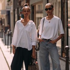 two fashion week attendees wearing updo hairstyles and white tops