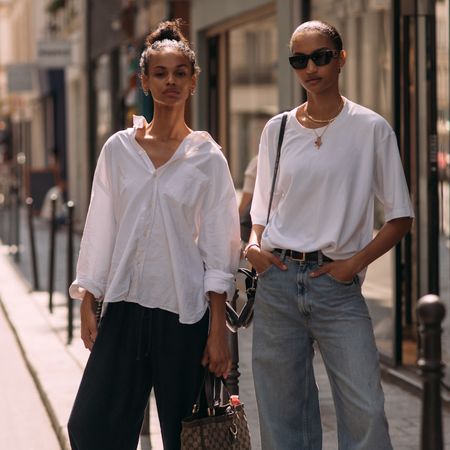 two fashion week attendees wearing updo hairstyles and white tops