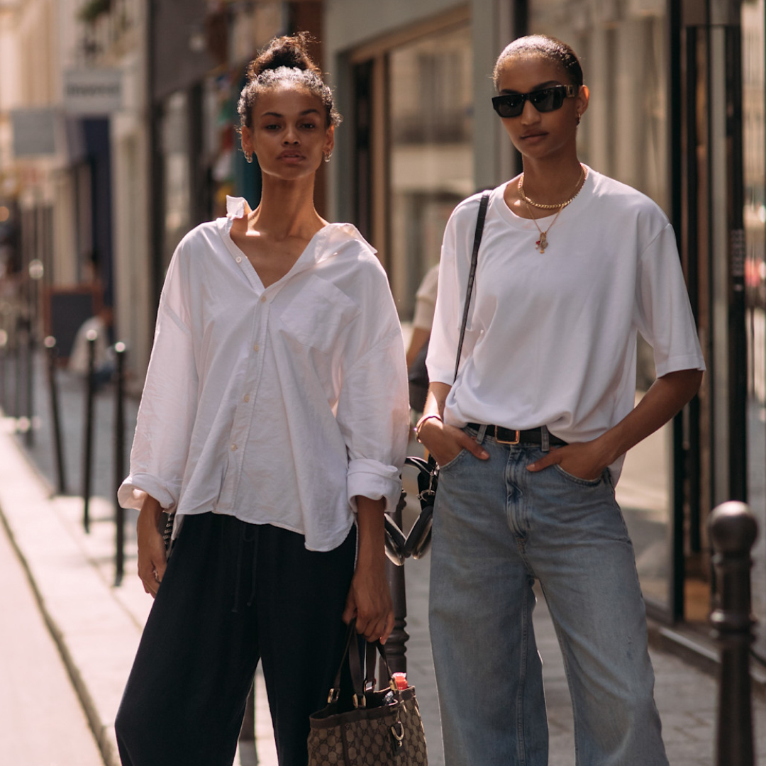 two fashion week attendees wearing updo hairstyles and white tops
