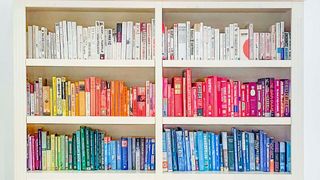 White bookcases with color coded books to suggest a bookshelf idea for small rooms
