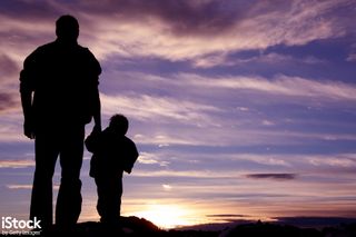 Father and child look out over sunset, from iStock