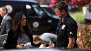 Alyssa Diaz and Nathan Fillion as Angela and John talking in The Rookie season 5