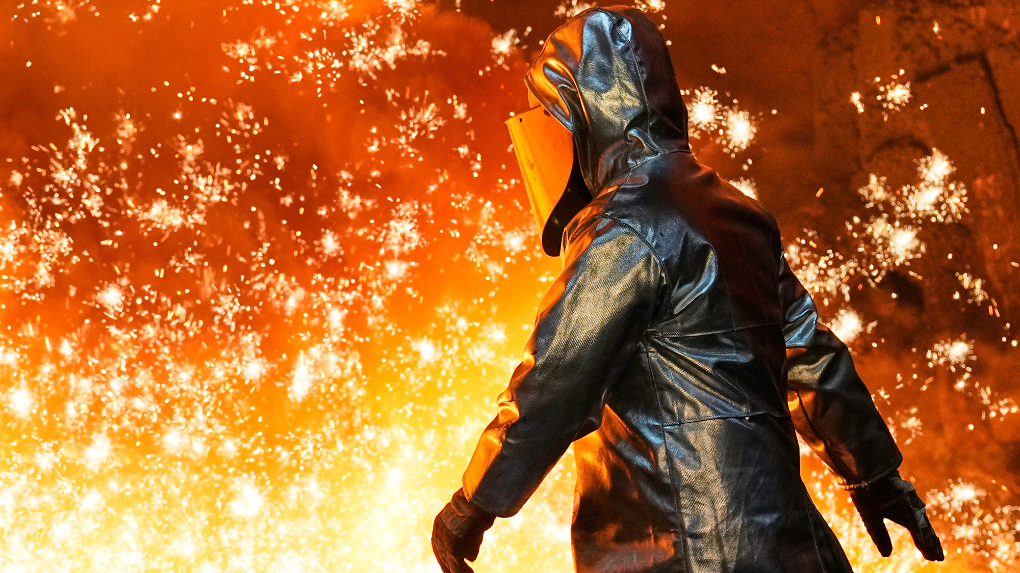A man is showered in sparks at the Thyssenkrupp steel mill in Duisburg, Germany