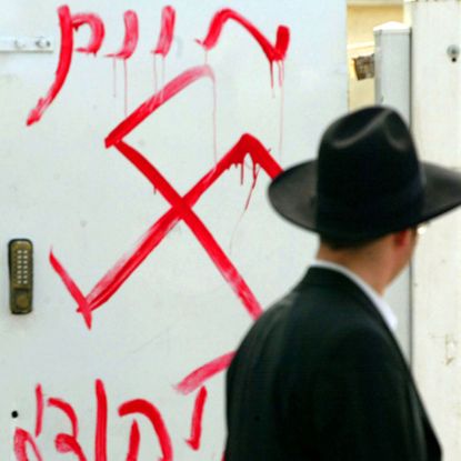 PETAH TIKVA, ISRAEL - MARCH 5:(ISRAEL OUT)A Jewish man looks at anti-semitic graffiti which was sprayed on the gate of a synagogue March 5, 2006 in Petah Tikva, near Tel Aviv, in central Isra