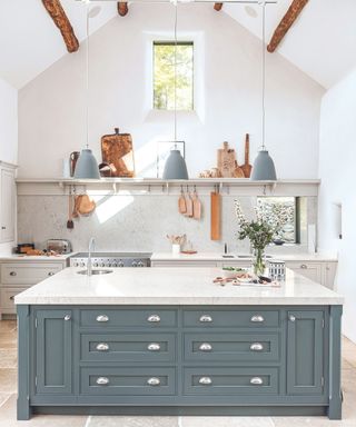 Blue/grey kitchen island drawers, white shelves, hang lamps