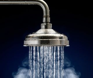 chrome shower head with water coming out creating steam