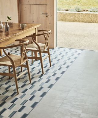 two different patterned vinyl flooring in a kitchen with dining area and chairs. Flooring: Diffusion Lux Diffusion Chambray Amtico