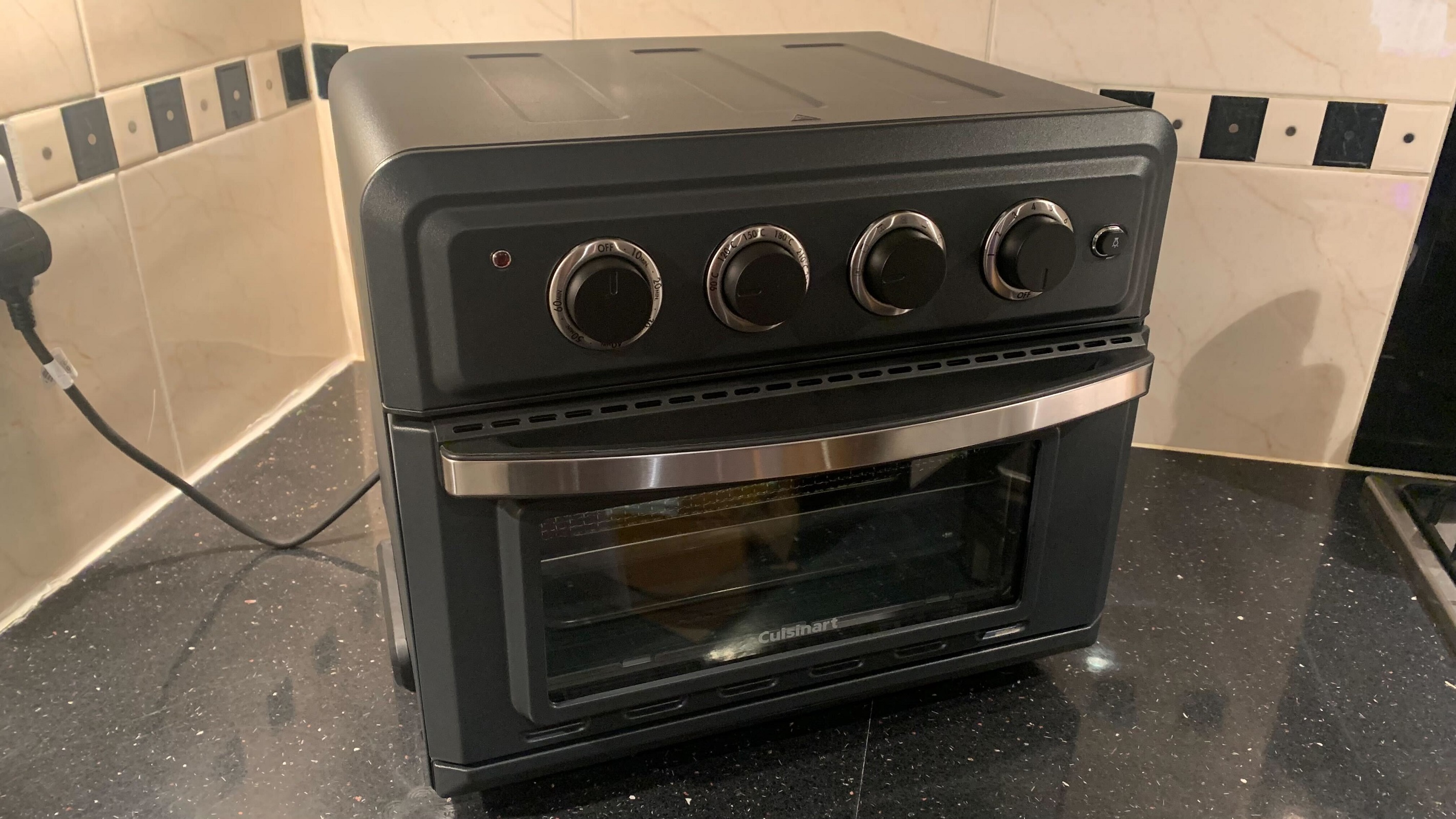 En Cuisinart Air Fryer Mini Oven står på et køkkenbord.
