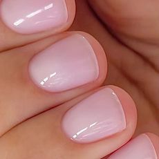 A close-up of a milky pink manicure