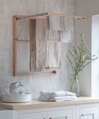 Wooden wall hung clothes dryer hung with linens
