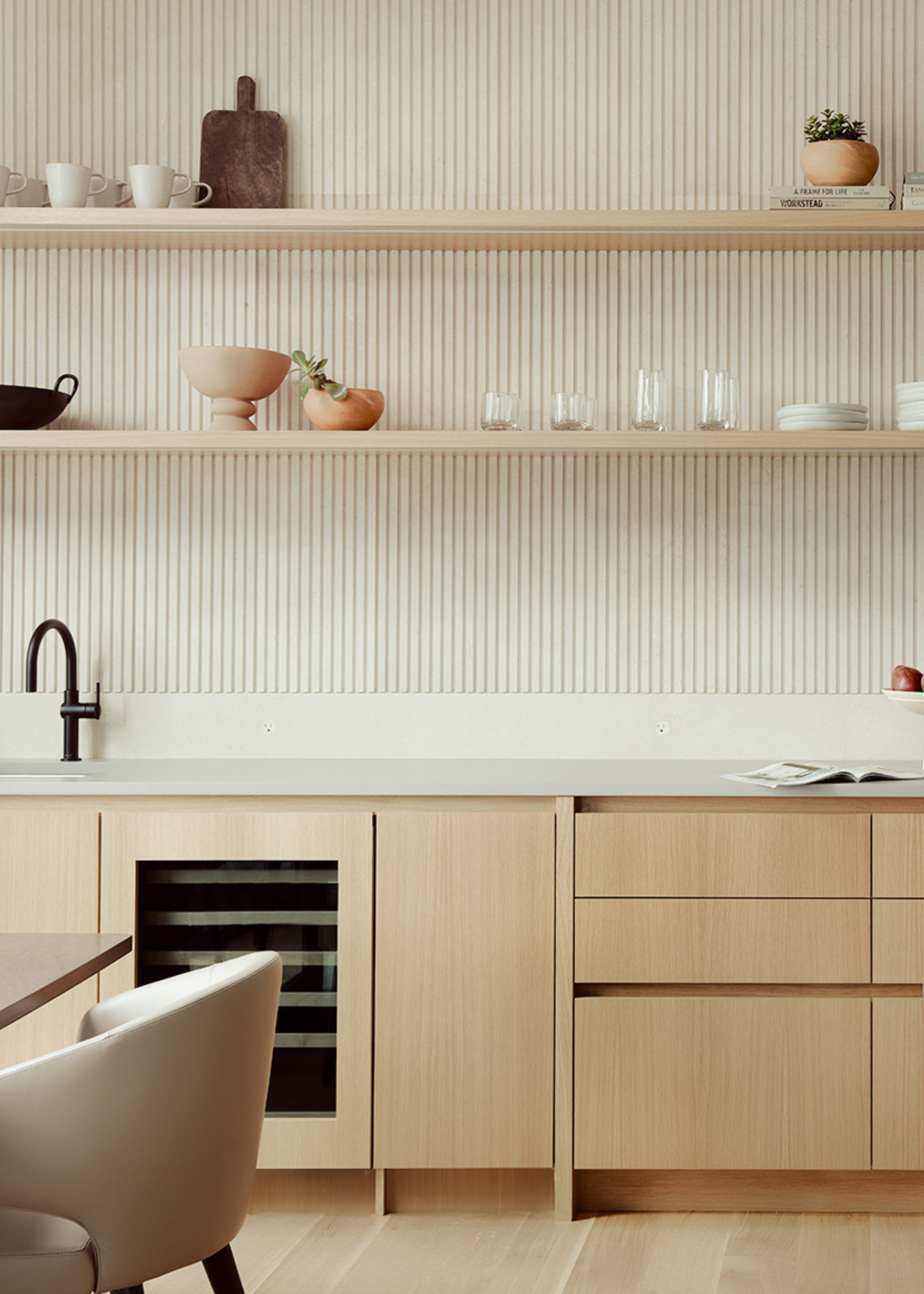 A kitchen with open wooden shelving, a panelled backsplash and wooden cabinetry