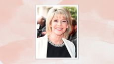 Ruth Langsford smiling with blonde bob and fringe, wearing a black crystal-embellished neck top and white blazer, on a pink watercolour background