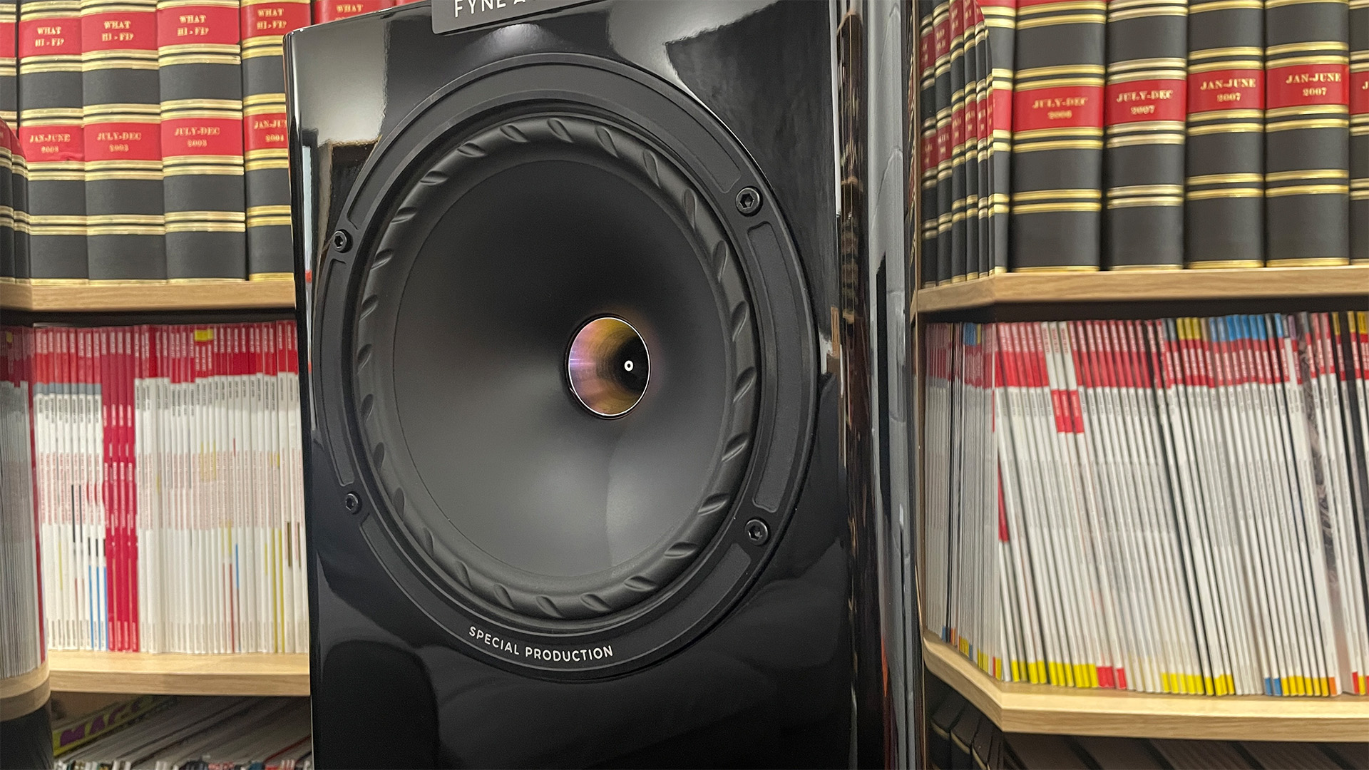 Fyne Audio F701SP standmount speakers one speaker showing mid/bass unit in front of bookcase