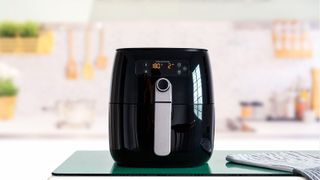 A black air fryer turned on to 180 degrees in a kitchen