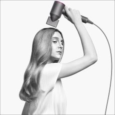 Woman using dyson supersonic hairdryer