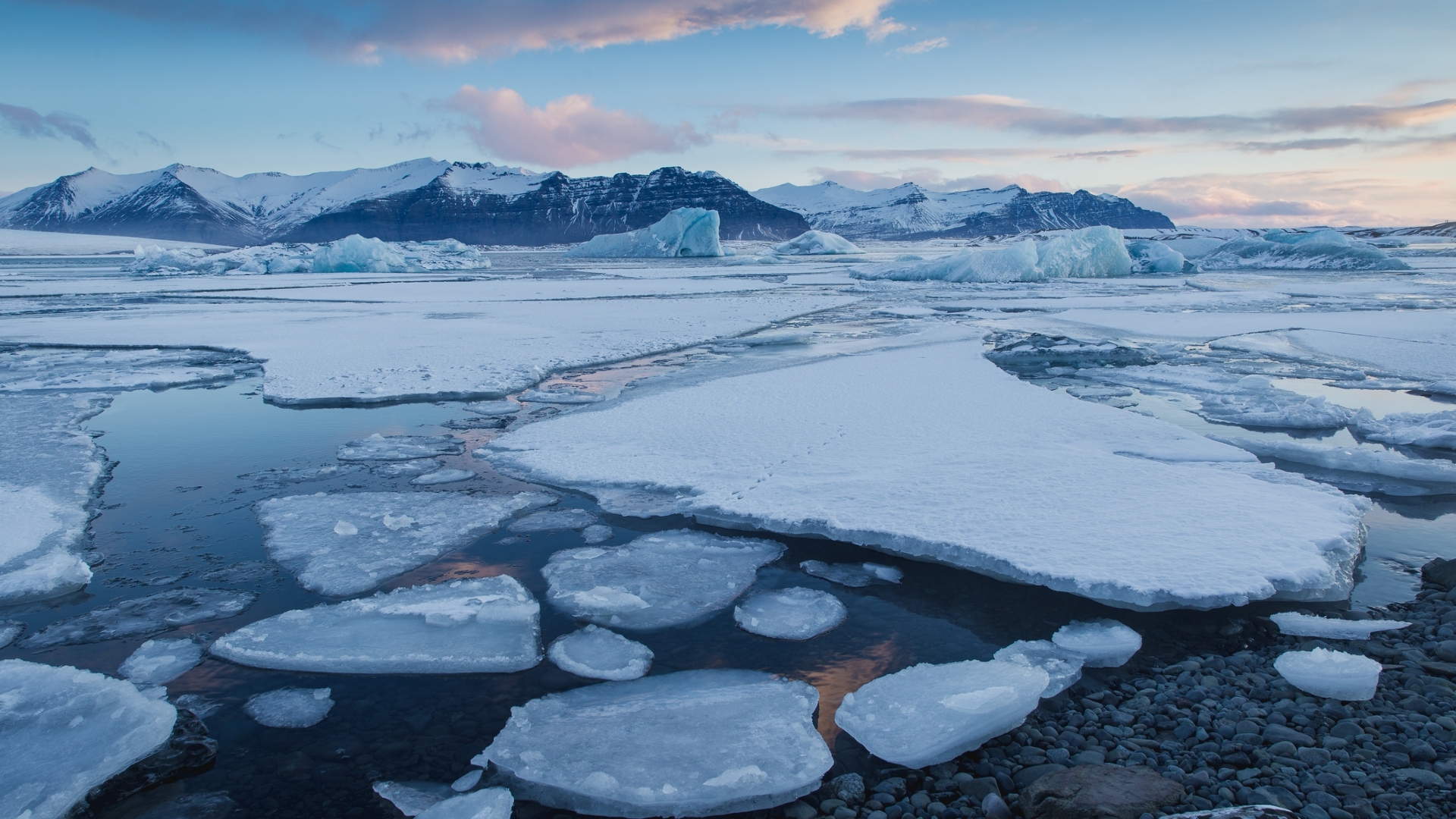 Gentle sunrise in Jokulsaron Lagoon where icebergs float and move slowly, dragged by the current.