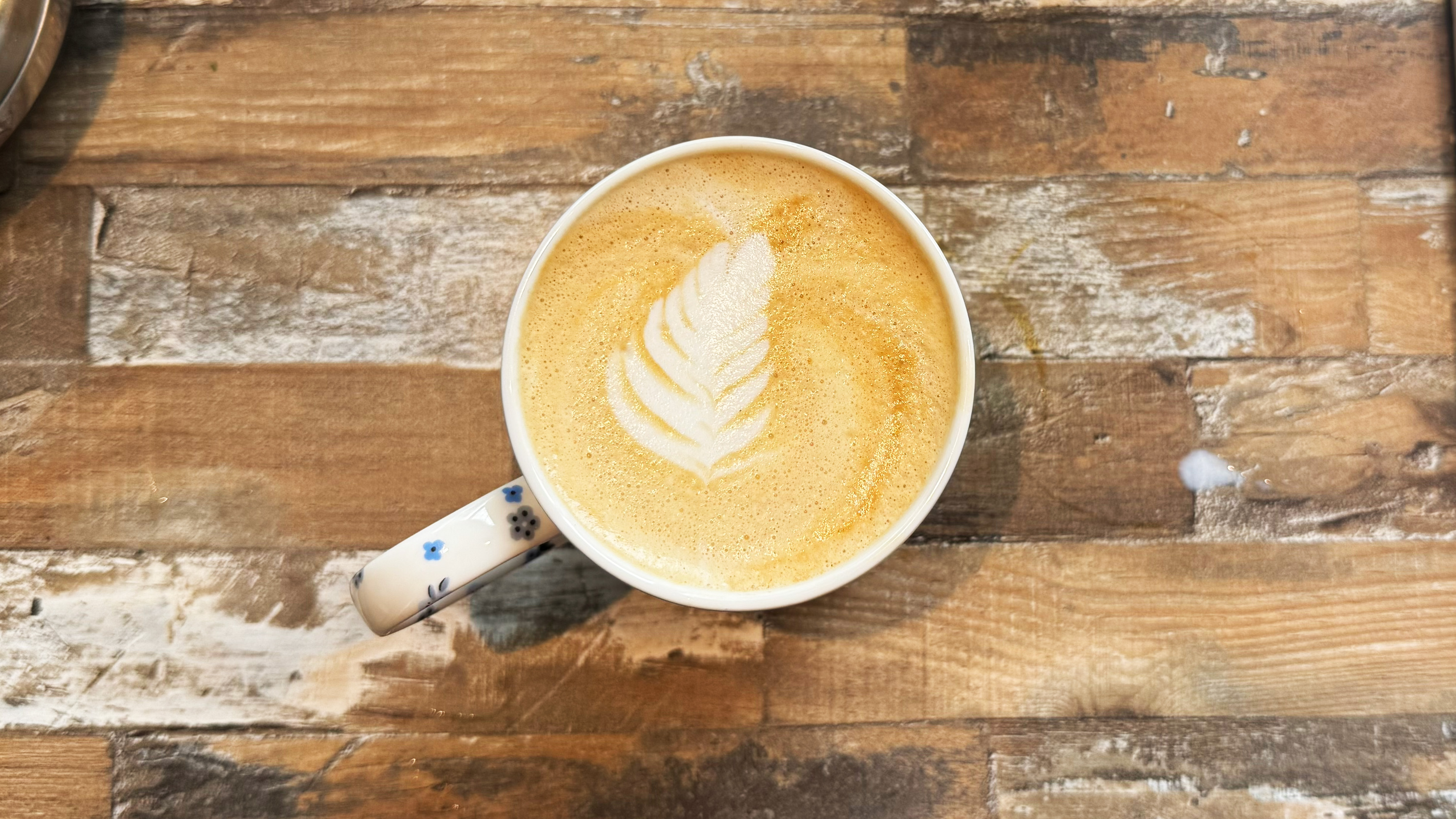 a photograph of auto milk steam on the breville bambino plus, showing latte art and milk texture