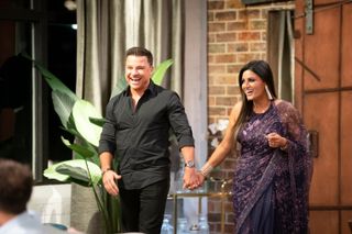 Sandy and Dan holding hands while entering a dinner party on MAFS