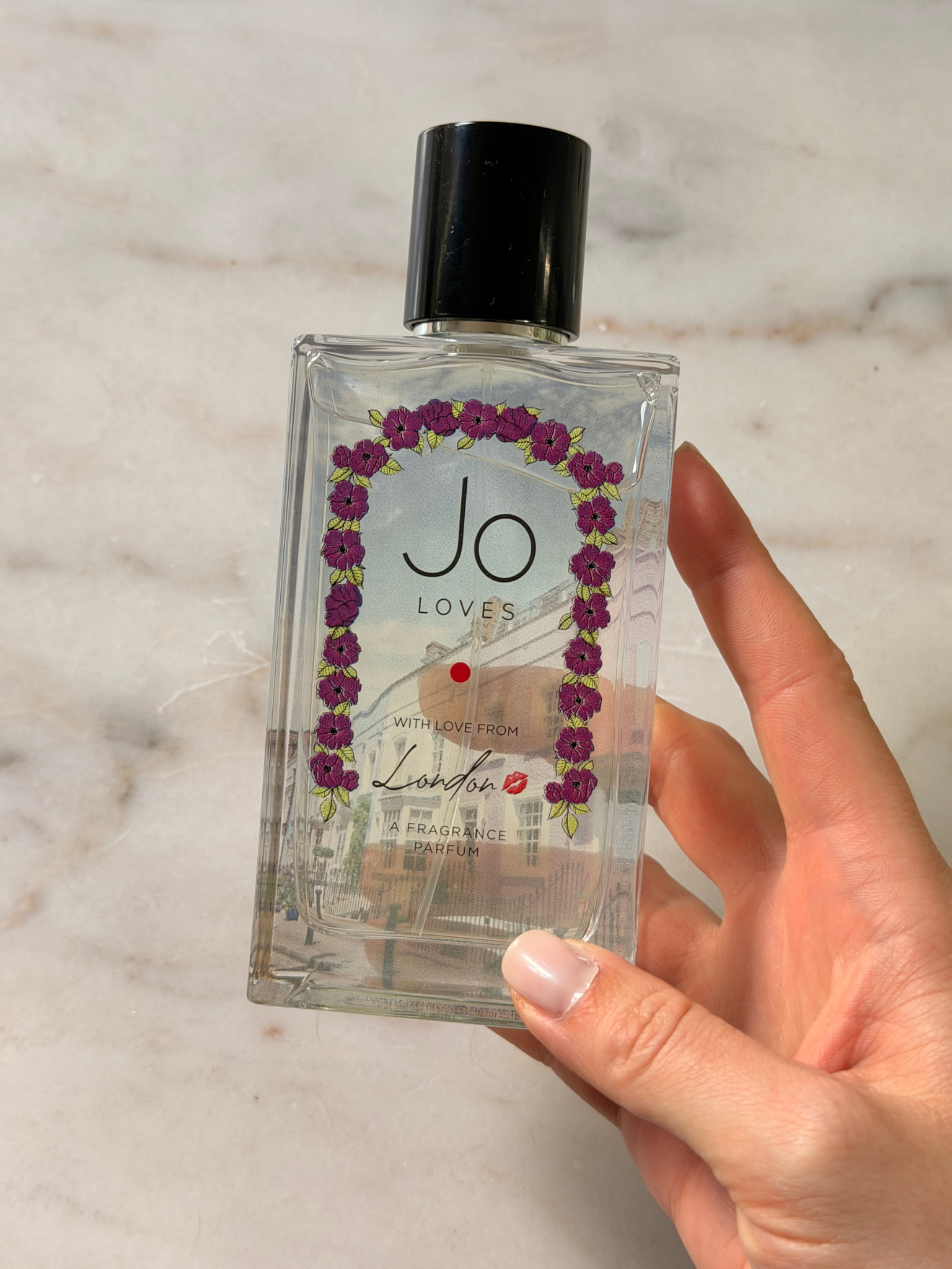 Grace holding a bottle of Jo Loves perfume