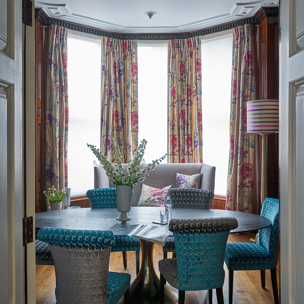 dining room with dining table and chairs with curtains on window