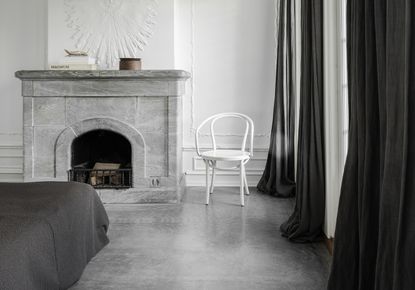 minimalist bedroom with grey floor and white chair