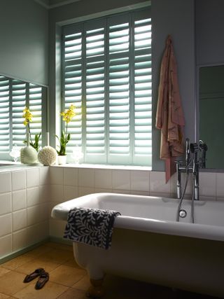 A small bathroom with painted shutters
