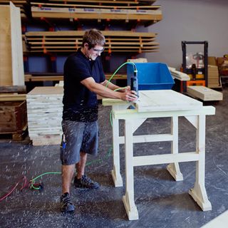 A Nüssli carpenter sands the edges of the panels