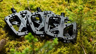 Three SQLab pedals laid out on grass