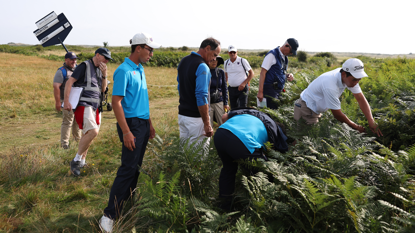 Golfers and marshals search for a golf ball