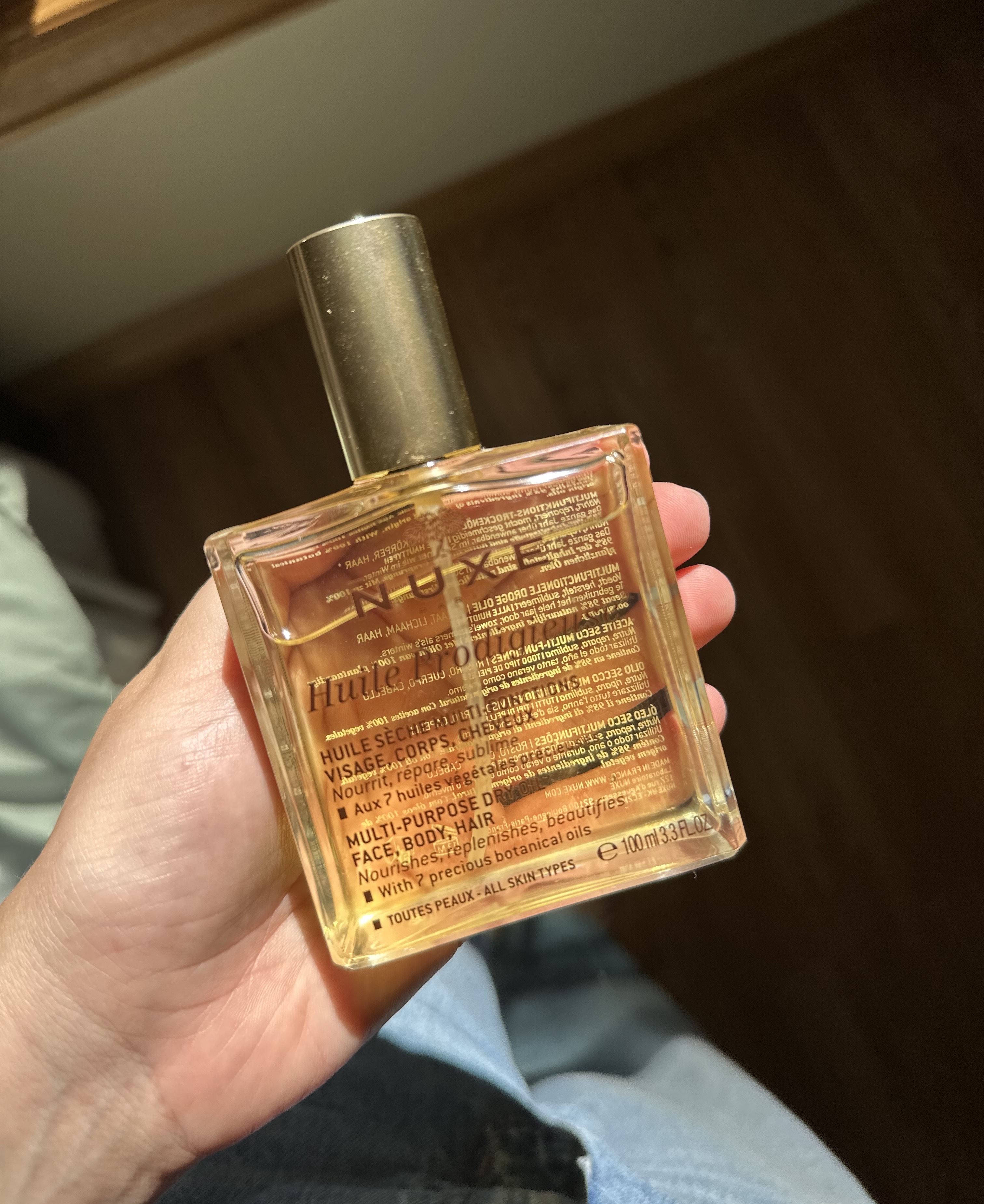 Beauty editor Kaitlyn McLintock holding Nuxe Huile Prodigieuse Multi-Purpose Dry Oil.