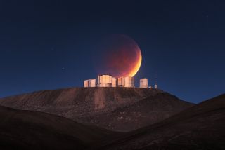 The eclipsed moon of May 26, 2021, shines behind the European Southern Observatory's Paranal Observatory in Chile.