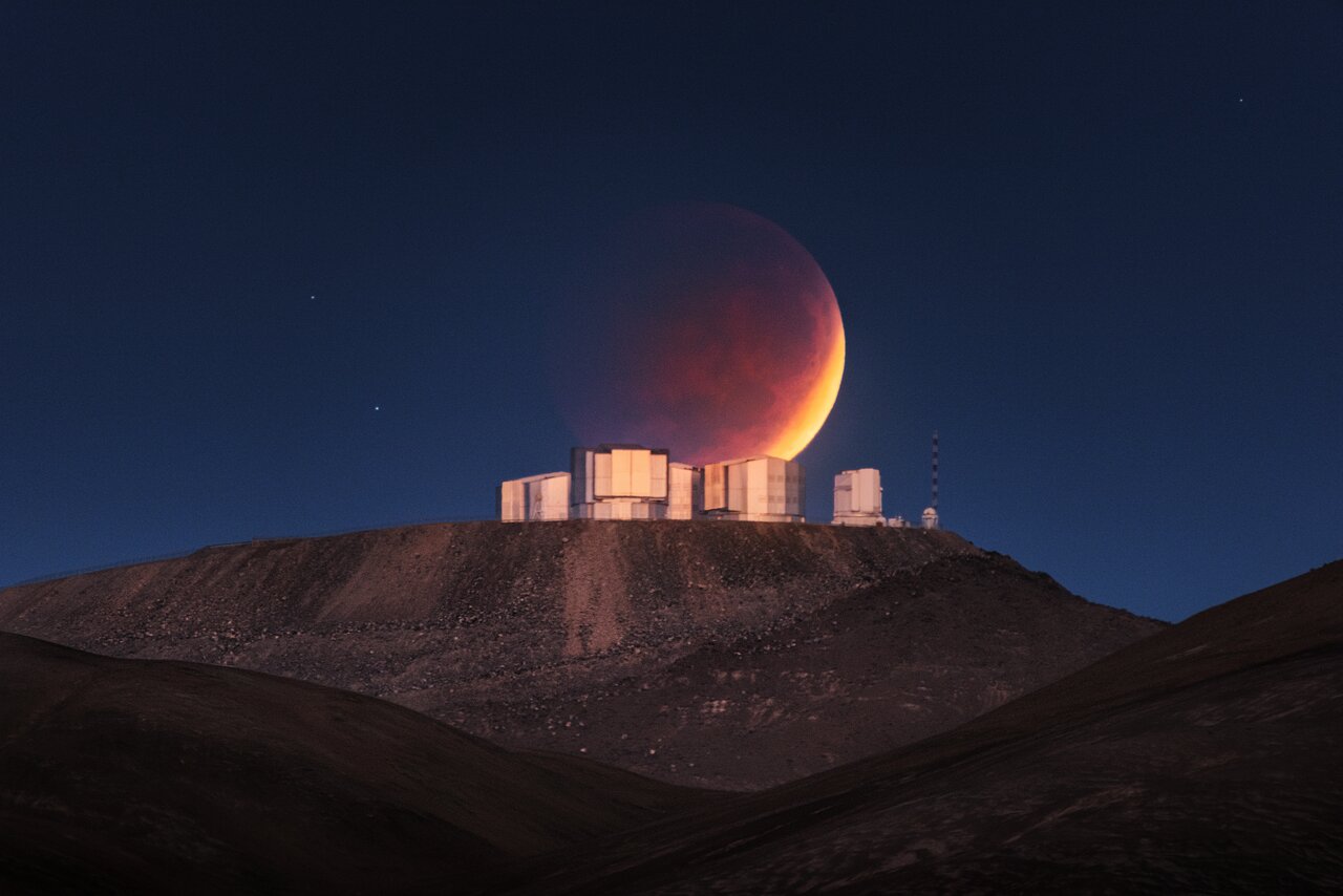 The eclipsed moon of May 26, 2021, shines behind the European Southern Observatory's Paranal Observatory in Chile.