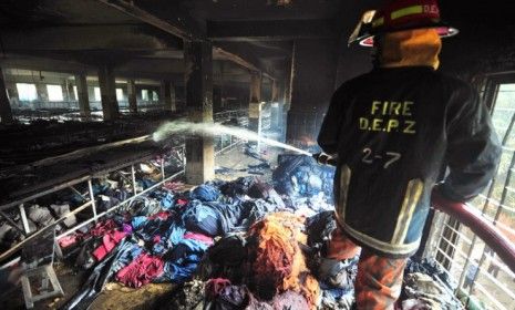 A Bangladeshi firefighter douses the inside of a garment factory outside Dhaka, Bangladesh on Nov. 25. At least 100 people were killed in the late Saturday night blaze that raced through the 