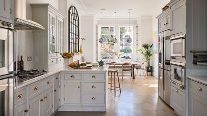 kitchen diner in a victorian home with white units and parquet floor