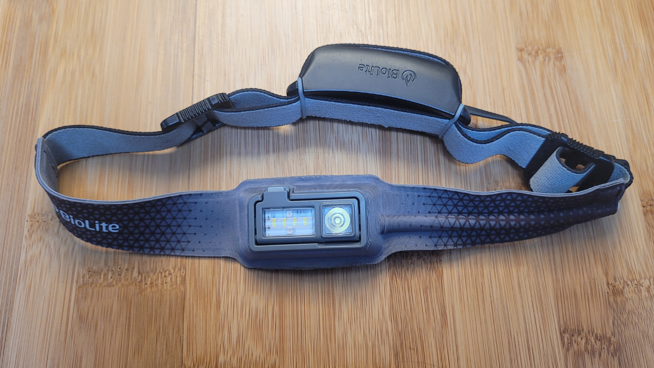 Review image of the BioLite HeadLamp 330 resting on a bamboo worktop.