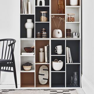 boxy shelving with painted interior recesses with everyday objects inside
