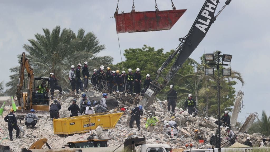 Rescue workers dig through the Champlain Towers South debris pile.