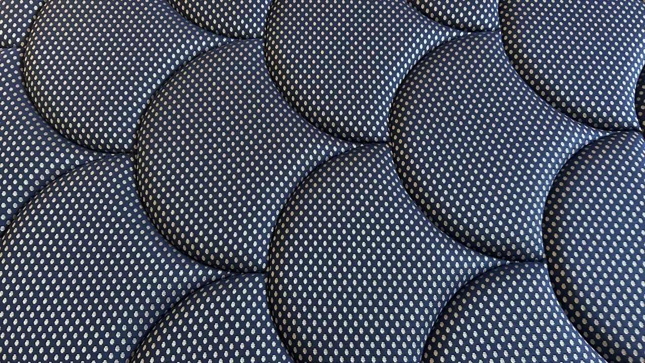 Close detail images of the DreamCloud Luxe Memory Foam mattress, showing design features like the quilted top of the bed and the handles sewn onto the sides