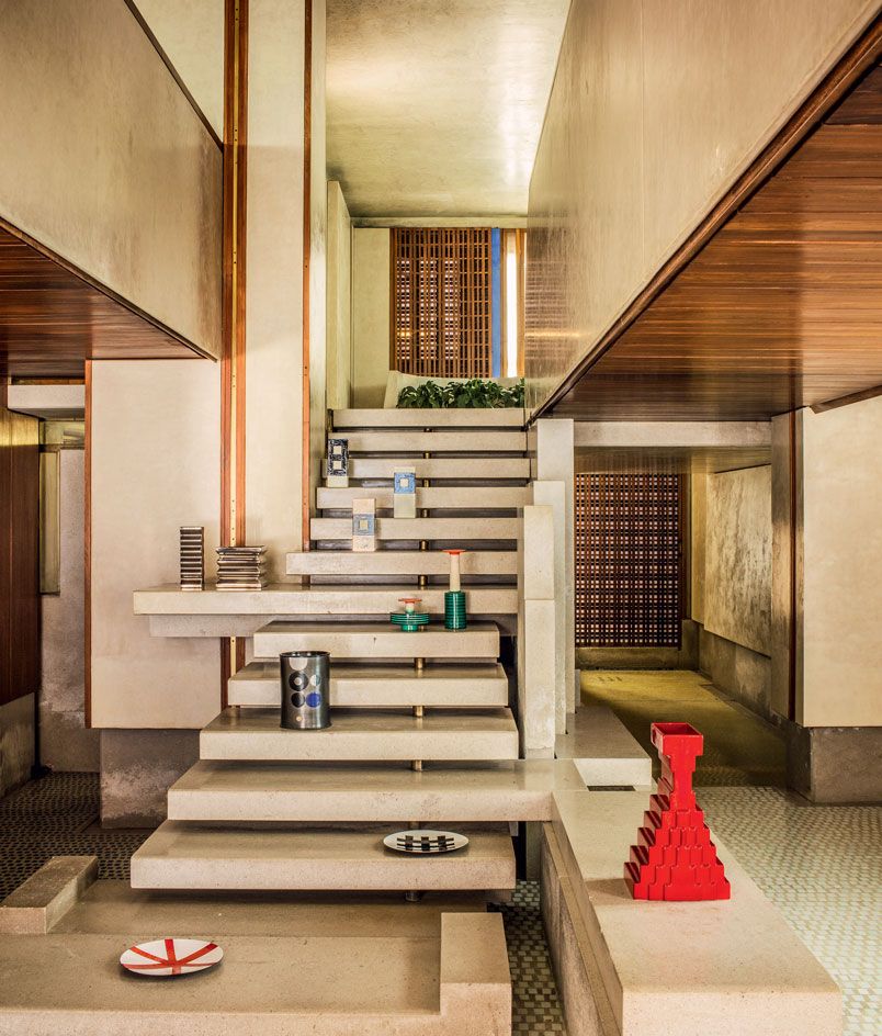 Sottsass&#039; pieces shown in the Negozio Olivetti in Venice. On the stairs, we see plates, vases, and other ceramics displayed.