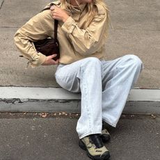 @meganadelaide wears a pair of faded jeans with a beige jacket and hiking trainers