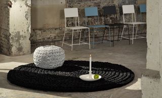 Black circular rug with white pouf