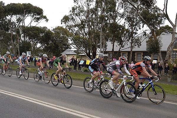 The peloton pass the school at Meredith around two minutes behind a lead group of six during the 143.1 kilometre third stage.