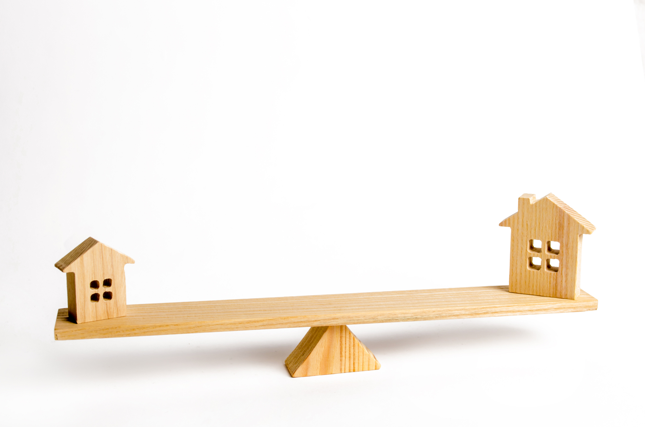 Two wooden homes sitting on a see saw