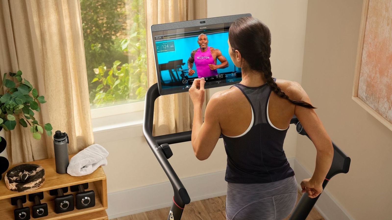 Wanita berlari di treadmill pintar Peloton Tread