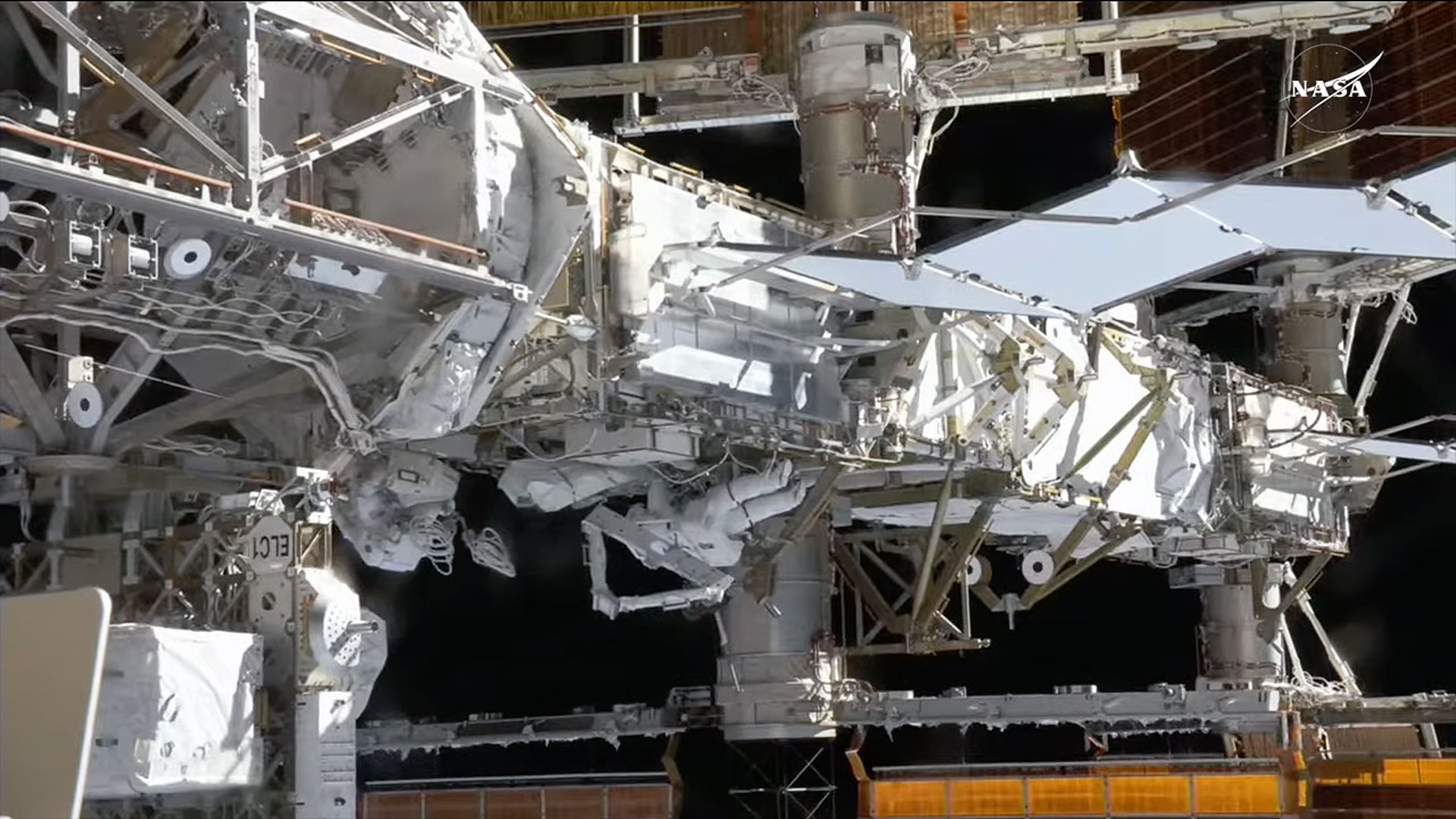 two astronauts work outside of the International Space Station during a spacewalk