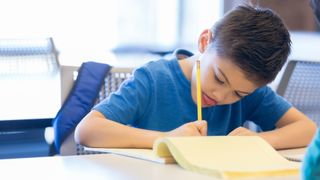 A boy sticking his tongue out while he concentrates.