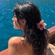 Photo of a woman wearing a half-up, half-down hairstyle with a floral claw clip