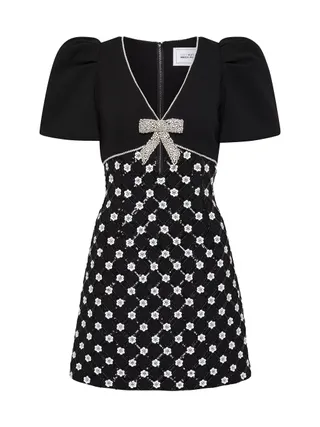 black minidress with puffed sleeves, a silver bow at the bust and crystal detail on skirt